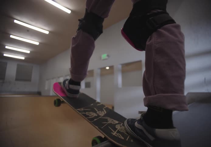 A girl rides her skateboard on the ramp