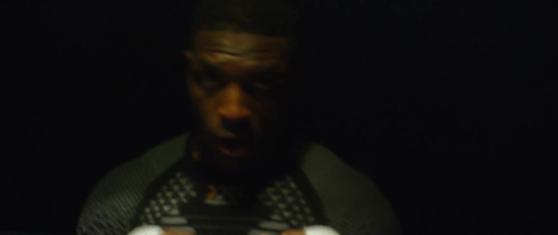 A man is shadowboxing in the dark