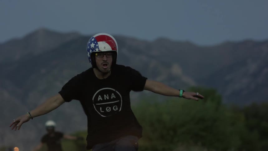 Man riding standing up with arms outstretched on a motorcycle