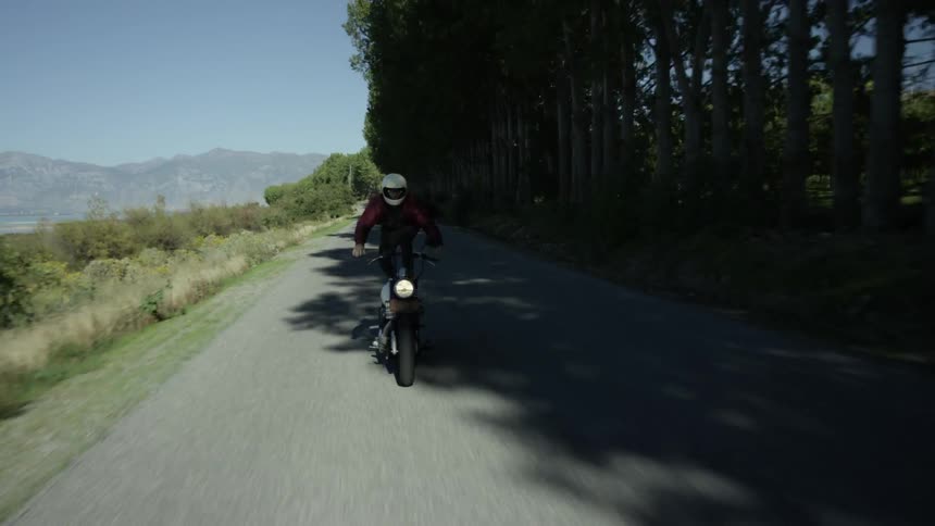 A man stands on his motorcycle as he is racing