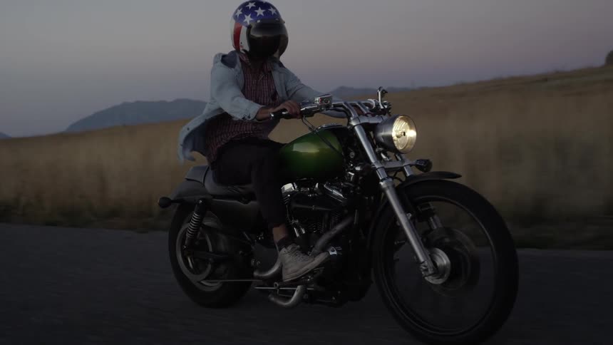 Man rides a motorcycle in a rural area