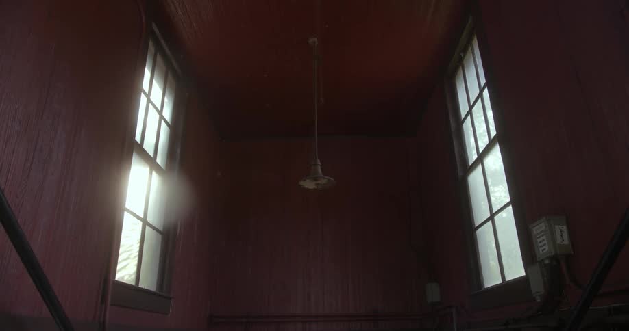 A single light fixture hangs down from the ceiling of a room