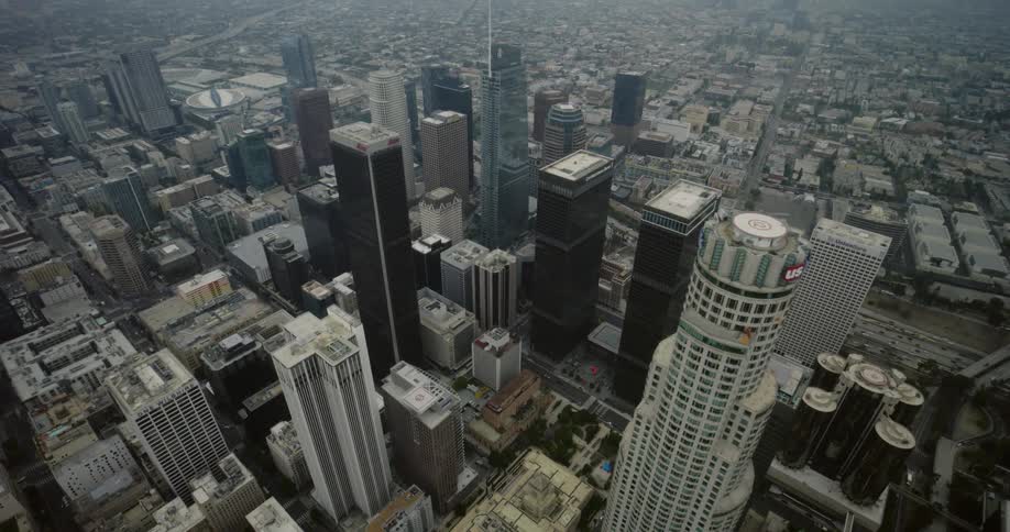 Skyscrapers loom over the surrounding buildings in a metropolis during the day