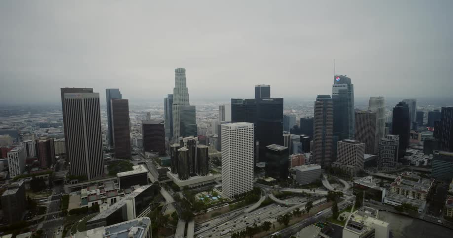 Skyscrapers loom over a freeway in a metropolis during the day