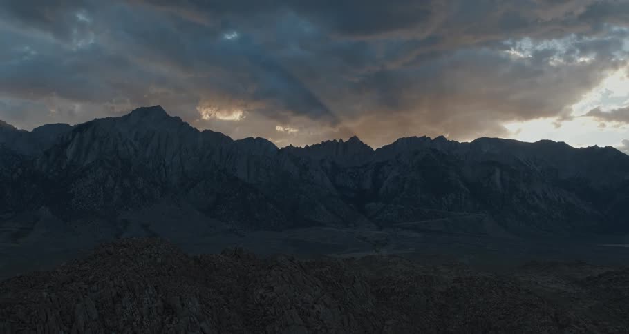 Light breaks behind dramatic cloud formations over Mount Whitney