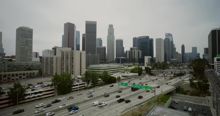 Traffic travels along a freeway through a metropolis during the day