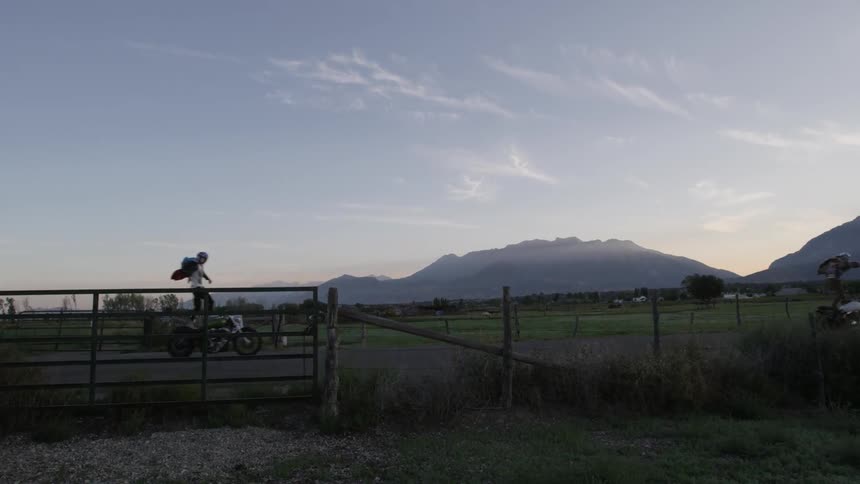 Motorcyclists balance on their bikes in a rural area