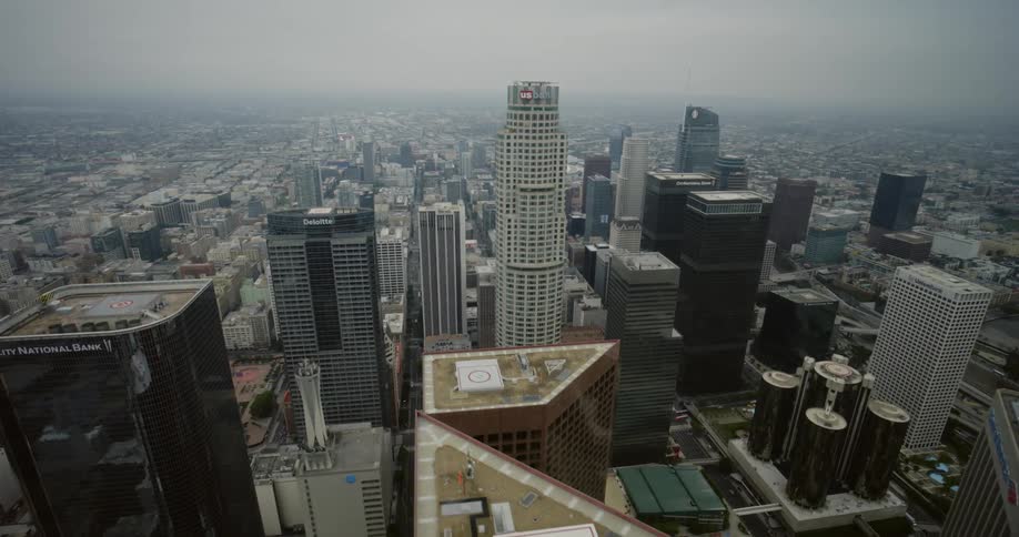 A banking skyscraper looms over the other skyscrapers in a metropolis on a foggy day