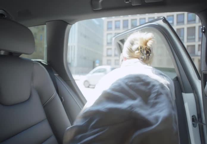 Blonde business woman leaves car