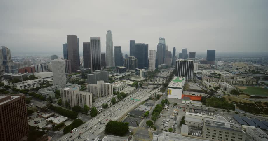 Traffic travels along a freeway through a metropolis on a cloudy day