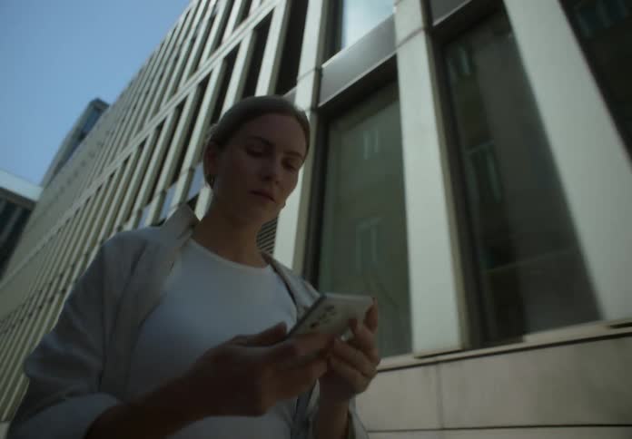 A woman checks her phone as she walks