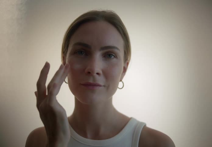 Woman gently applying facial cream