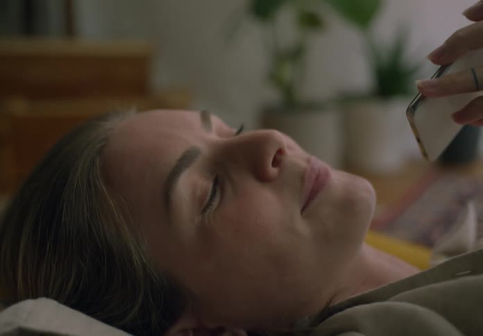 Woman lying on a cushion on the floor talking on the phone