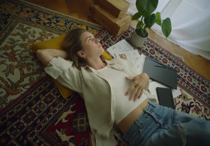 A woman is resting at home on the carpet