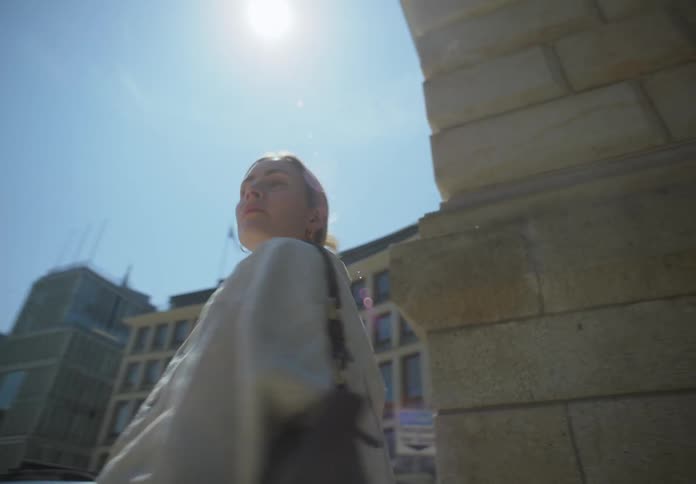 Blonde woman standing on a street corner and suddenly turning