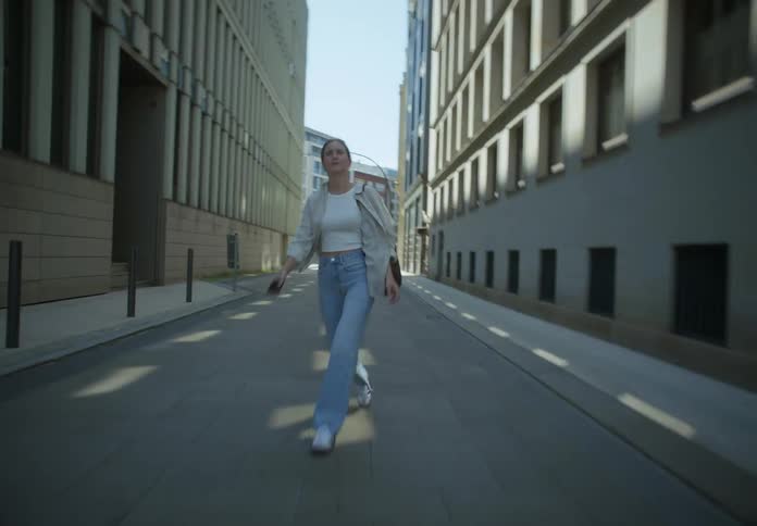 Blonde woman walks down an alley with hectic strides