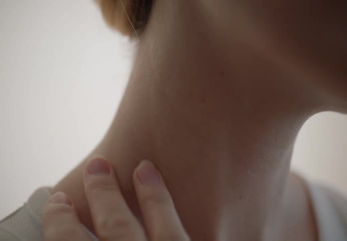 A woman rubs her neck