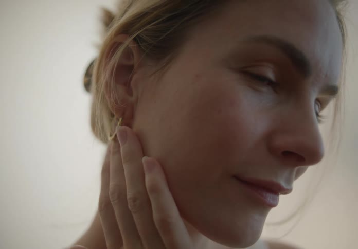 A woman puts on moisturizer