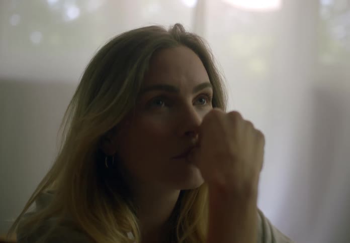 Contemplative blonde woman sitting indoors