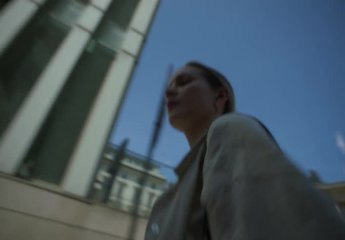 A woman walks through a city on a clear day