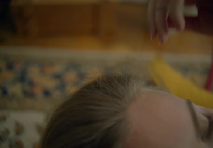 A woman brushes her hair back