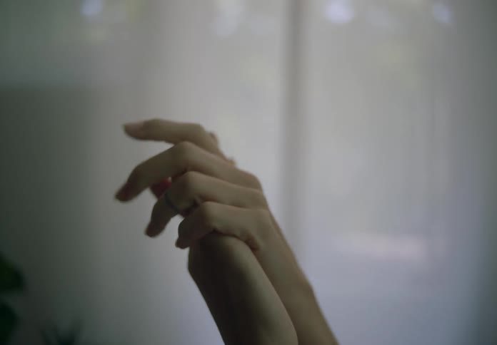 Woman with tattooed arm rubs one hand against another