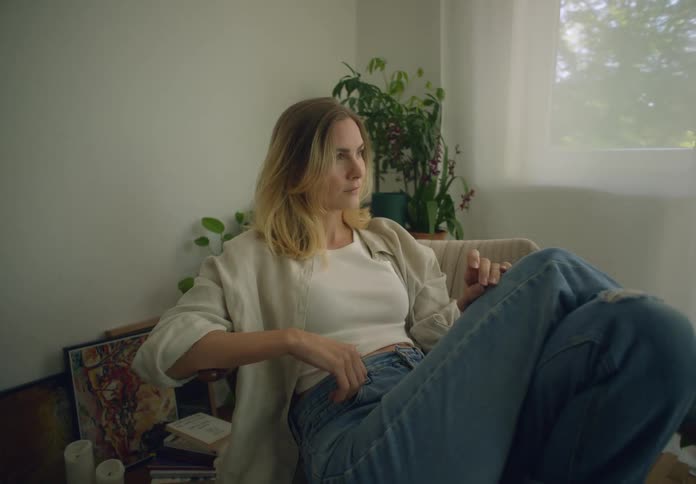 A woman sits in an armchair at home