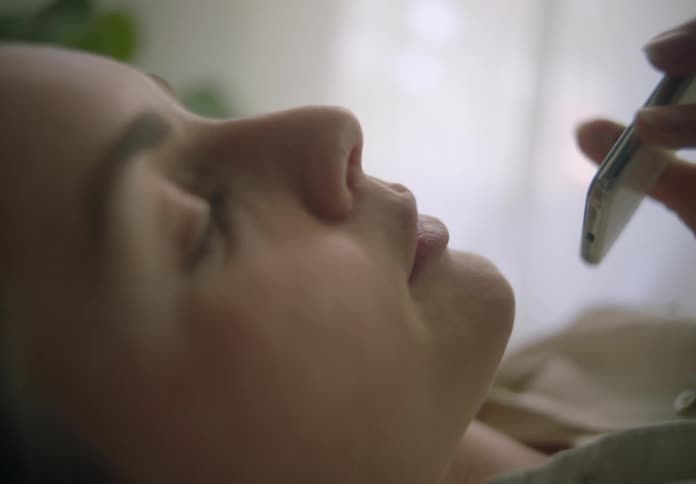 Woman lying down at home talking on the phone