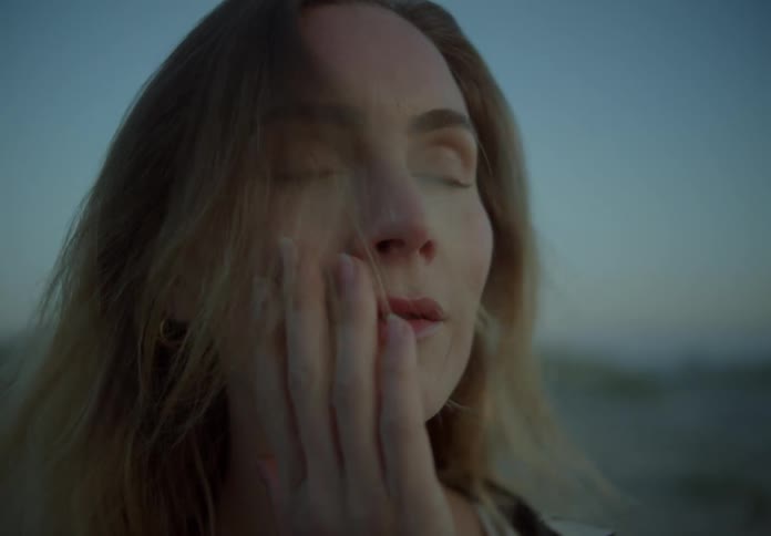 A woman rubs her face