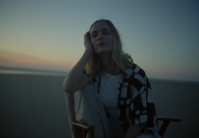 A woman sits in a chair on the beach