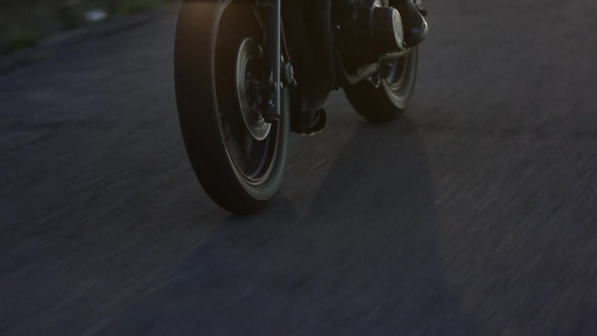 A motorcycle is driving down a road fast