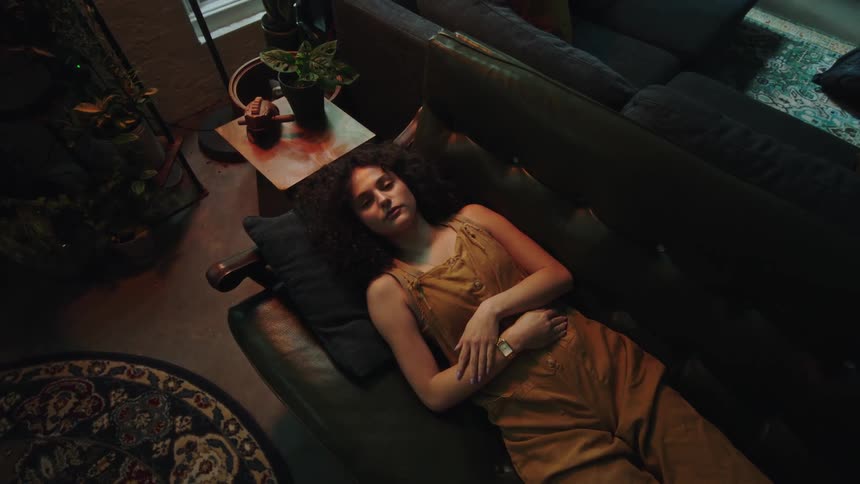 A woman is resting on the couch