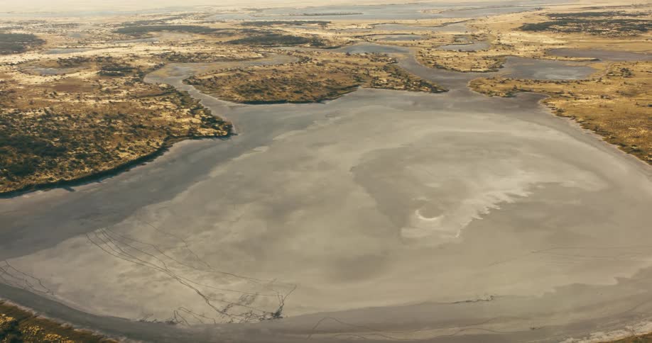 Aerial view of winding rivers gracefully converging into a serene and expansive lake