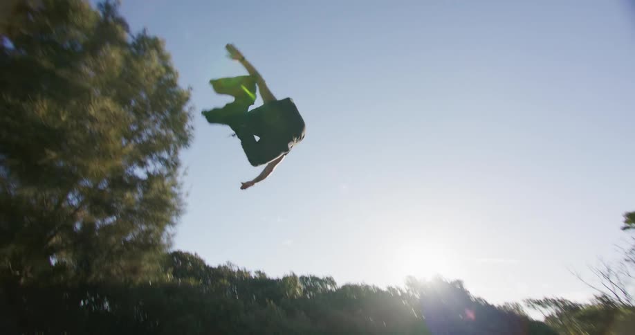 A man in roller skates skates up a ramp and does a flip in the air before landing on the other side