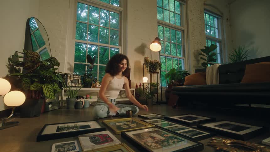 A woman drinks and looks at paintings