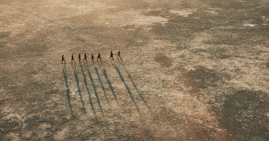 Group of bushmen crossing the salt pan on foot