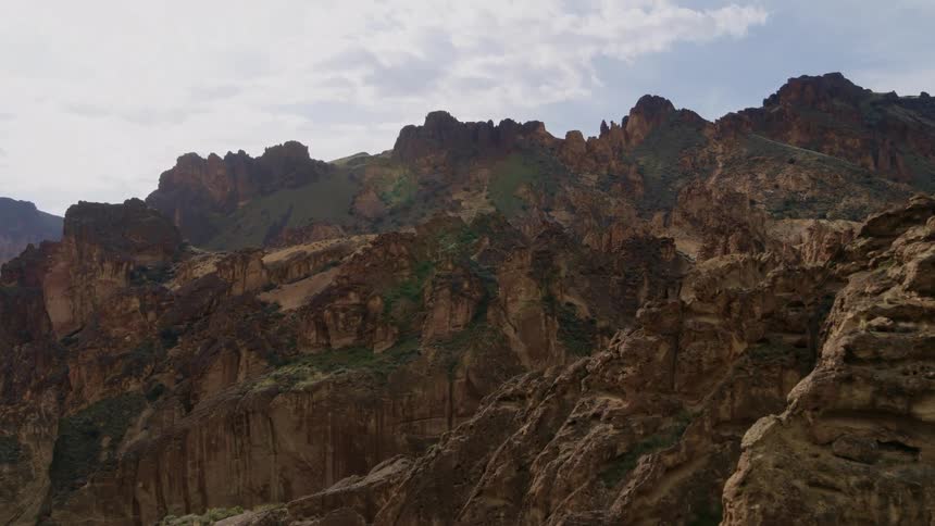 Low approach over beautiful golden cliffs and weather carved rock formations