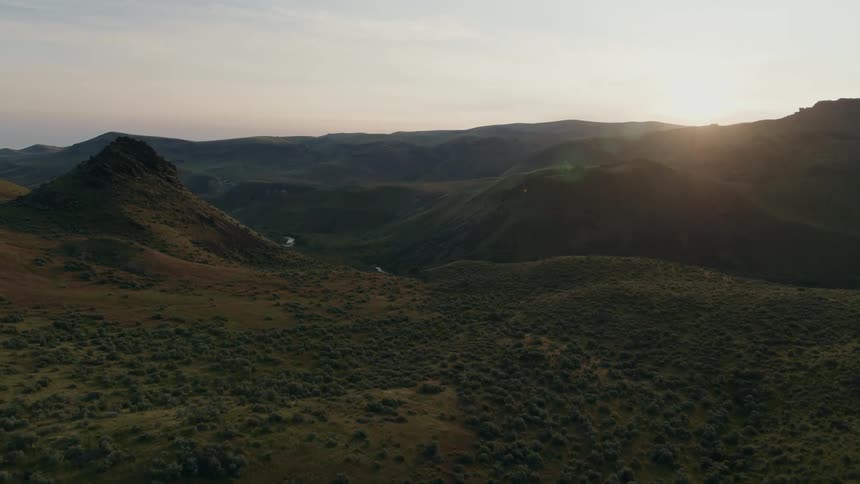 Sunshine glows along a rugged and wild mountain valley