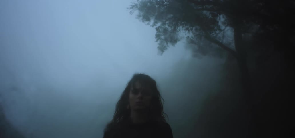 A woman walks in the foggy rain