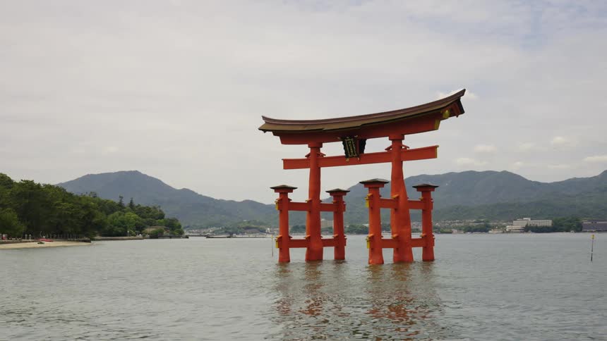 A beautiful reach arch that is constructed in an asian style stands above the water