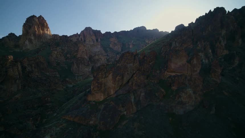 Ascending along the edge of a rugged ridgeline silhouetted by the sun