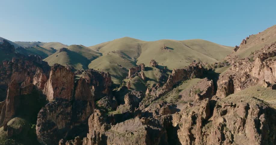 Jagged rock outcroppings protrude out from undulating green hills