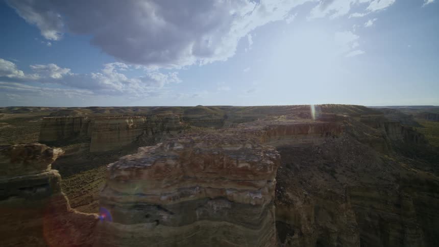 Skimming along the side of a beautiful mesa in the badlands on a sunny day