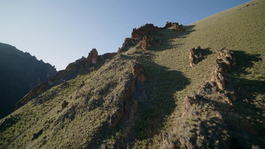 Low skim above the jagged and rocky surface of a mountainside