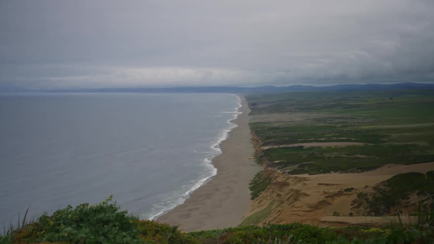 Ocean waves gently wash upon the beach that lines this coast