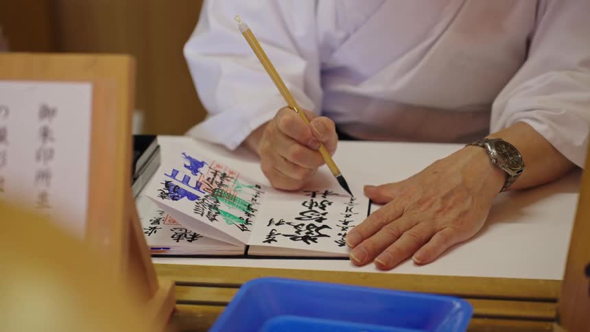 The focused man diligently writes japanese characters in his notebook immersing himself in the art of calligraphy