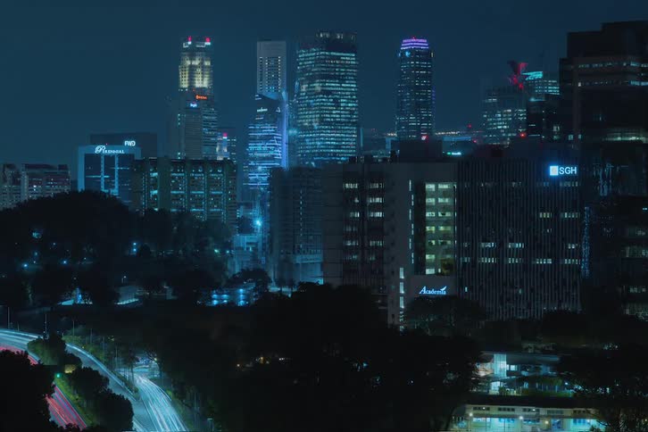 The camera rises to reveal a construction site rising at night in the city