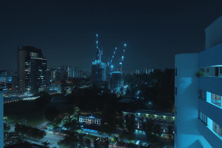 A skyscraper being constructed in a metropolis city at night