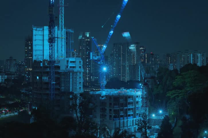 Two tall buildings in a metropolitan area are constructed using large cranes