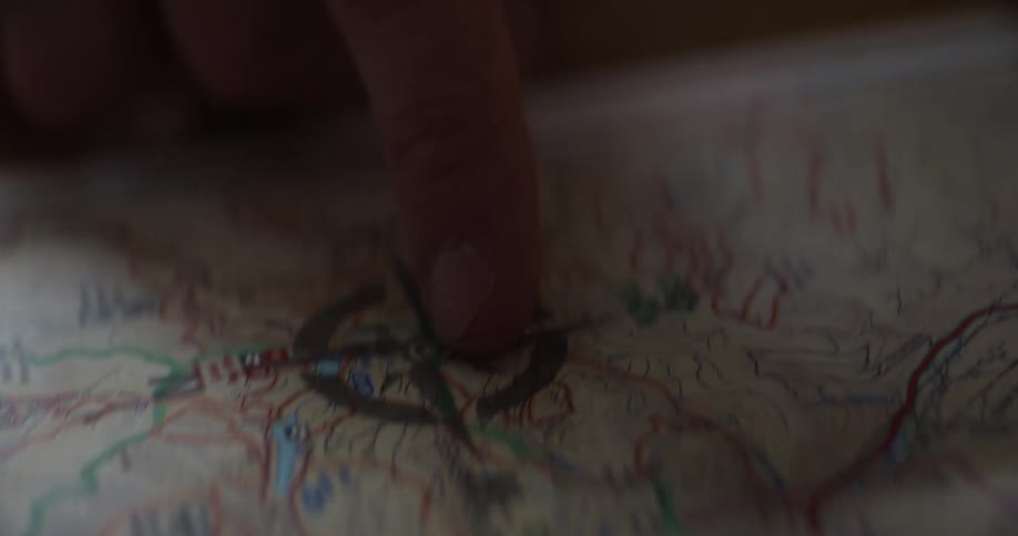 Person traces route on paper map